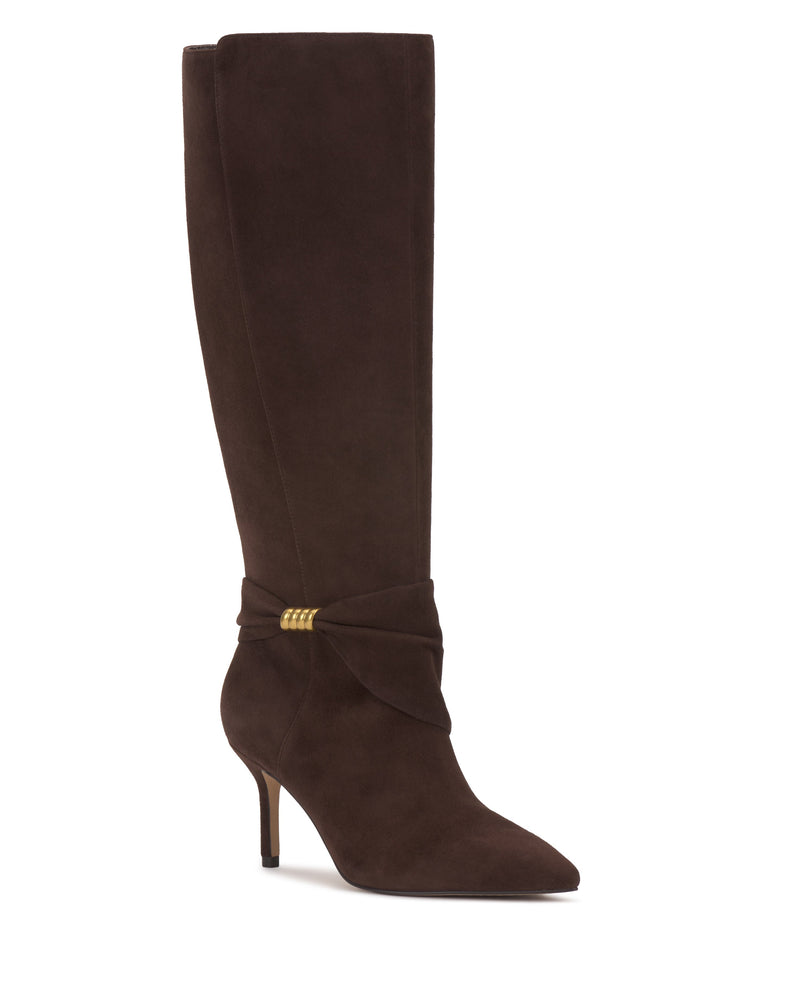 The Meezo Extra Wide Calf Knee High Boot by Vince Camuto is crafted from dark brown suede and showcases a pointed toe, skinny heel, and decorative wrap detail with gold hardware rings at the ankle.