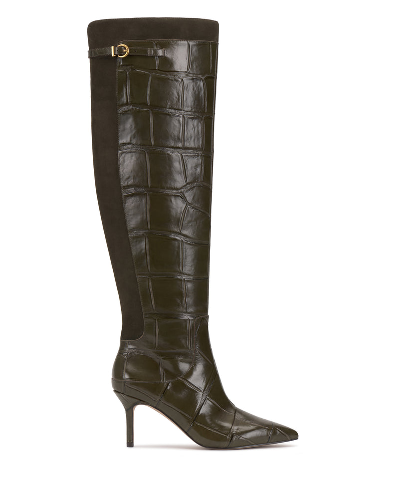 The Meleis Wide Calf Over the Knee Boot by Vince Camuto features a tall, dark brown, crocodile-embossed leather design with a pointed toe, thin high heel, side buckle detail, and a suede panel running along the back.