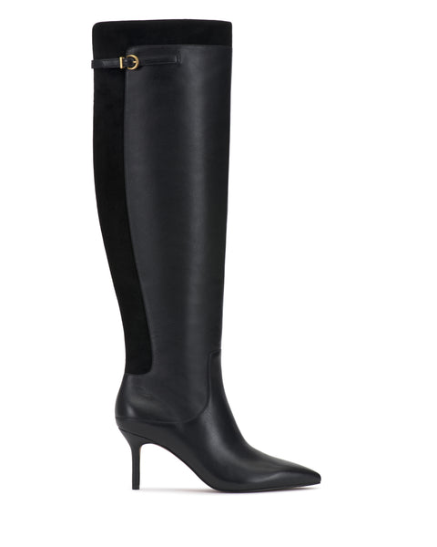 The Meleis Over the Knee Boot by Vince Camuto is a black boot featuring a pointed toe, stiletto heel, and a gold buckle detail near the top. The back of the boot is crafted from suede, creating a striking contrast with its smooth leather front.