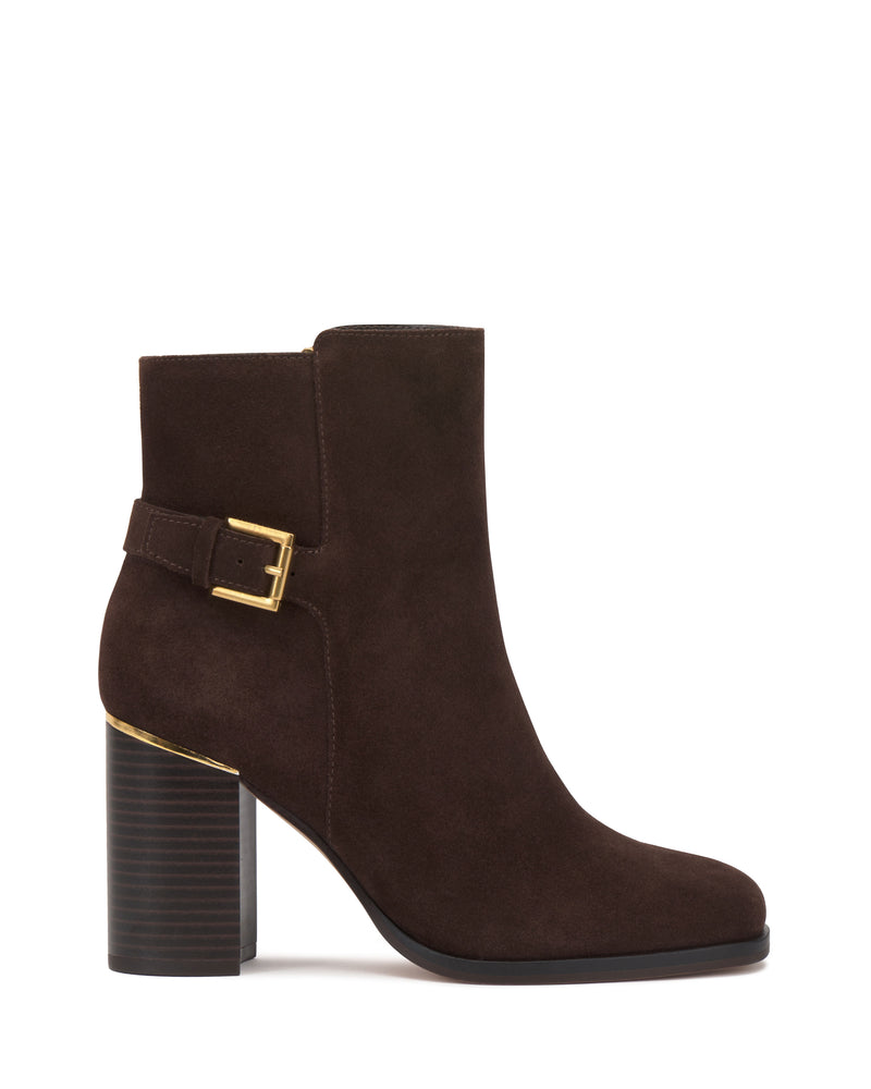 Introducing the Melvani Bootie by Vince Camuto: a dark brown suede ankle boot featuring a chunky block heel with layered detailing and a gold accent near the sole. This stylish design is finished with a round toe and elevated by a side buckle in gold.