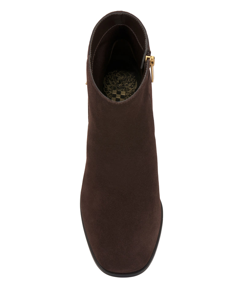 A top view of the Vince Camuto Melvani Bootie—a single brown suede ankle boot accented with a gold buckle detail and a patterned insole—displayed on a plain white background.
