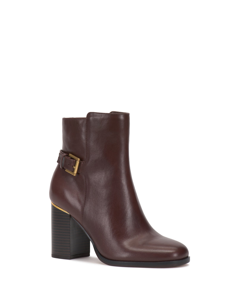 The Vince Camuto Melvani Bootie is a brown leather ankle boot featuring a chunky high heel, side buckle detail, and rounded toe, displayed against a white background.