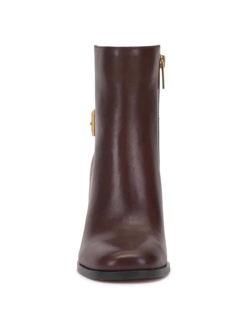 Front view of the Vince Camuto Melvani Bootie in dark brown leather, featuring a gold side zipper, a rounded toe, and a flat black sole, set against a plain white background.