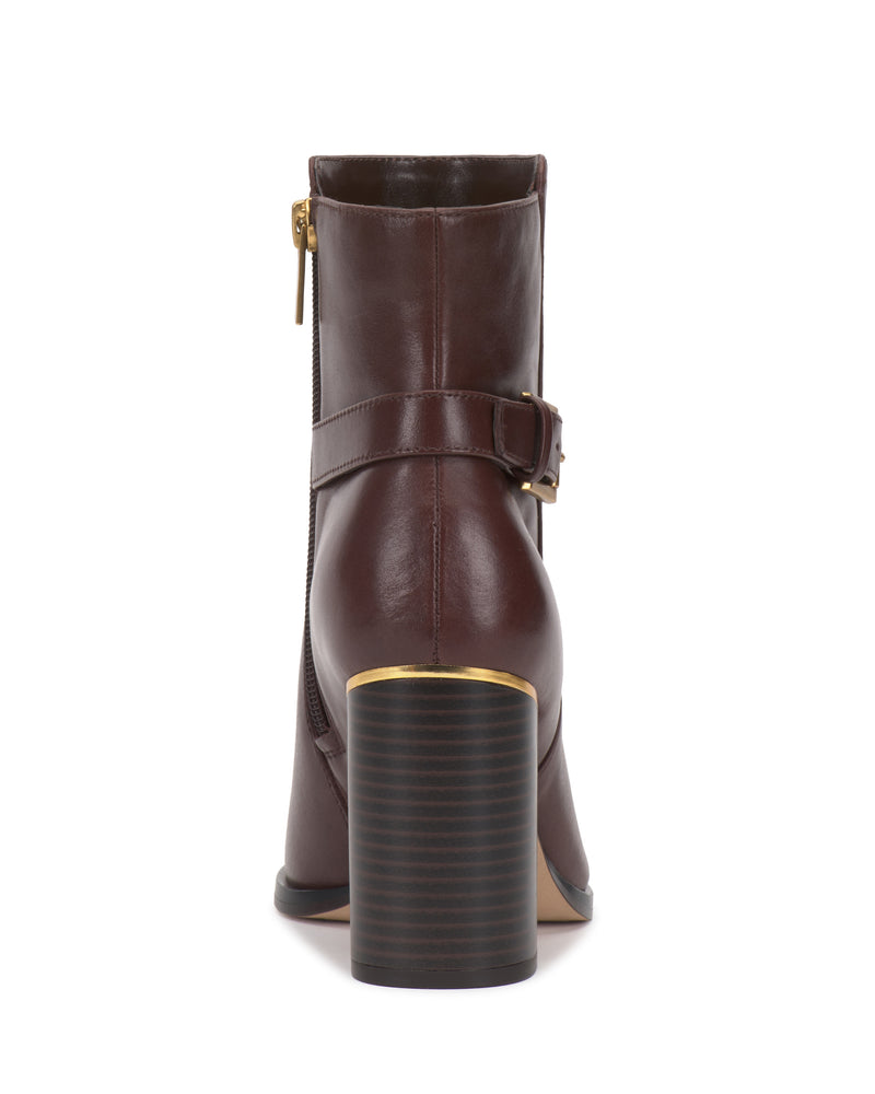 The Melvani Bootie by Vince Camuto is a brown leather ankle boot featuring a block heel, gold zipper, and a matching buckle strap, displayed from the back against a white background.