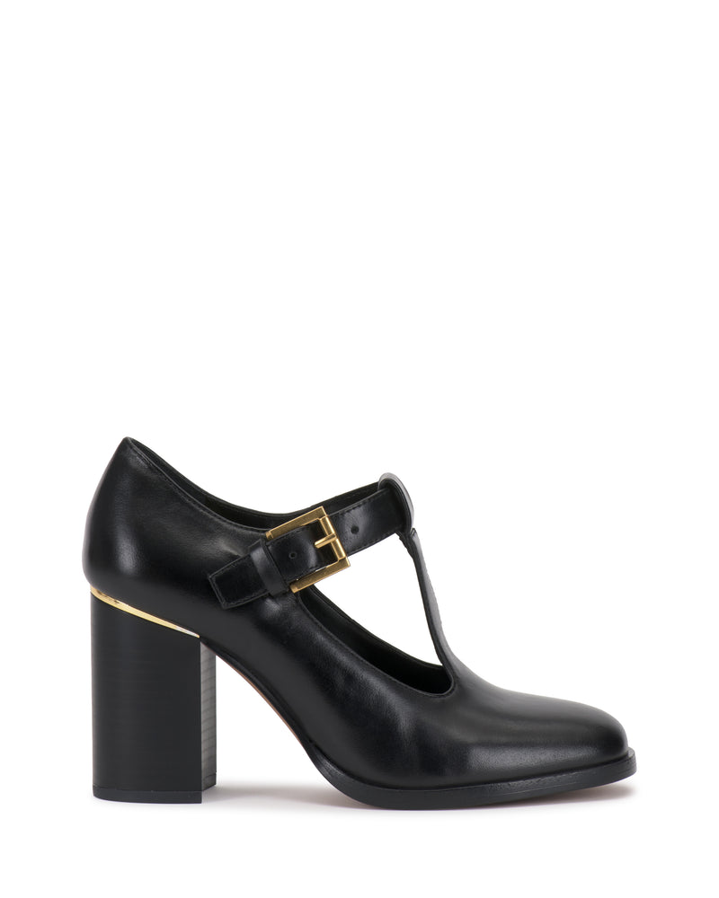 Micha Pump in black with a T-strap, block heel, square toe, and gold-tone buckle, blending vintage charm with a feminine style.