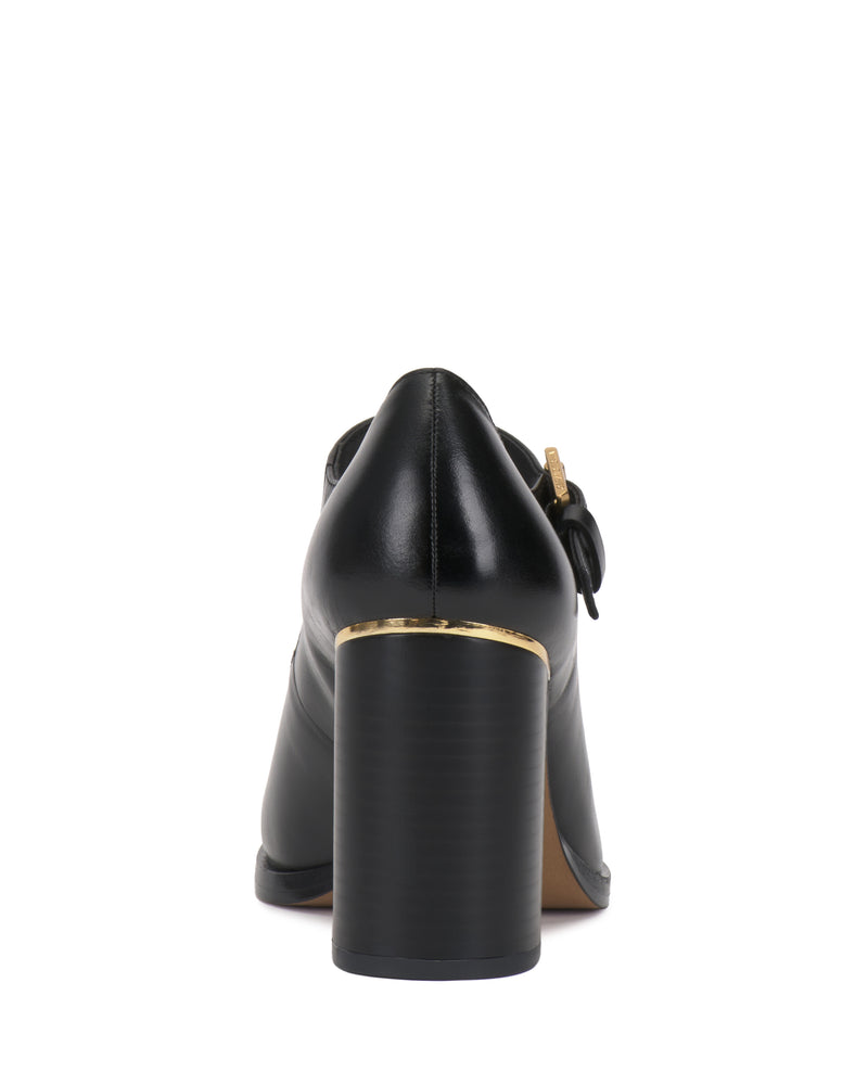 Vince Camuto Micha Pump in black, featuring a T-strap design, a thick block heel, and gold-toned metal detailing for a vintage charm.