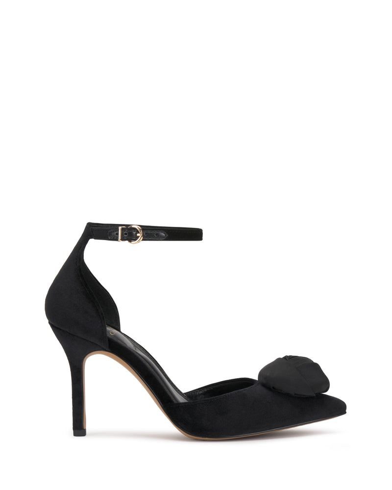 The Mirezzo Pump by Vince Camuto is a black high-heeled shoe featuring a closed pointed toe, chic ankle strap with small buckle, stiletto heel, and a decorative front bow.