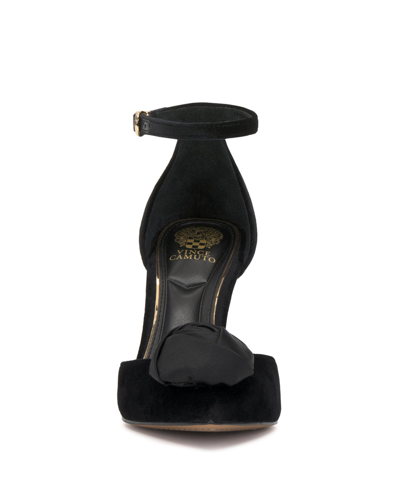 The Vince Camuto Mirezzo Pump is a black suede stiletto with an ankle strap, open toe, front decorative bow, and gold branding on the insole.