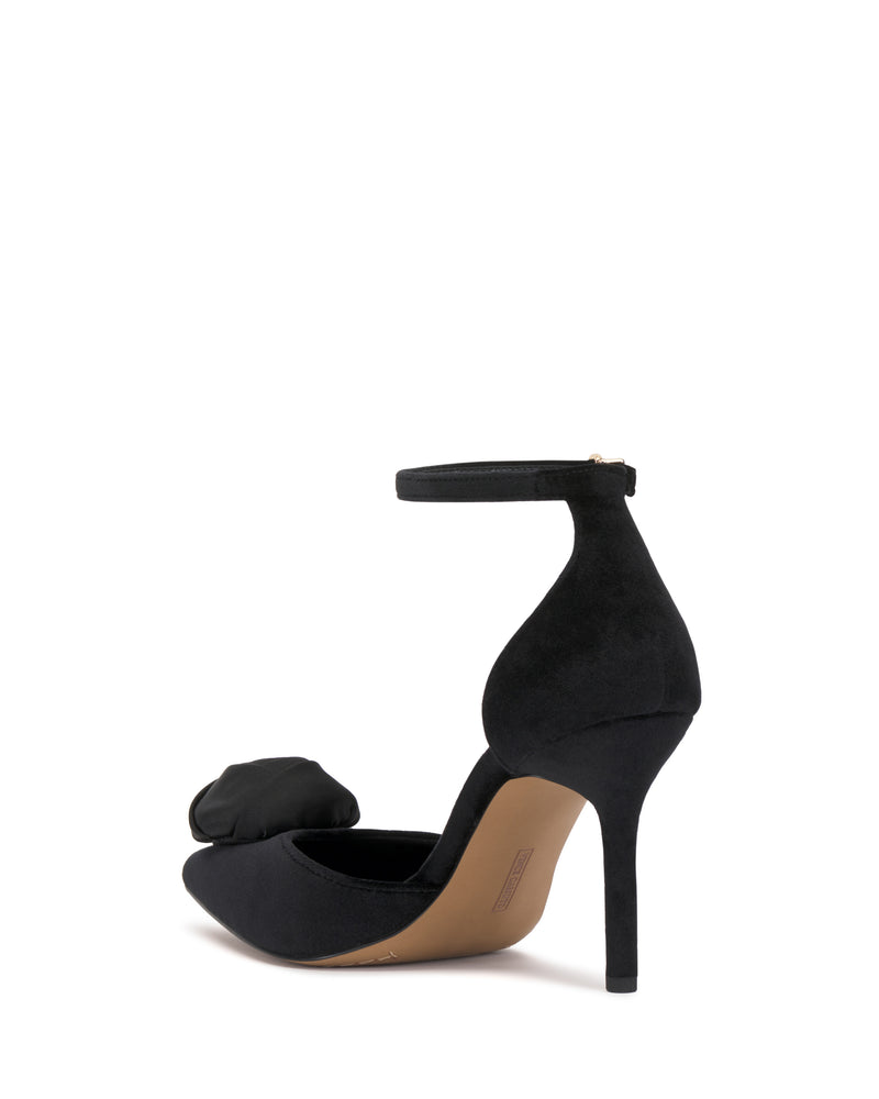 The Vince Camuto Mirezzo Pump features an ankle strap, pointed toe, bow detail on the front, and sleek stiletto heel, shown from the back on a white background.