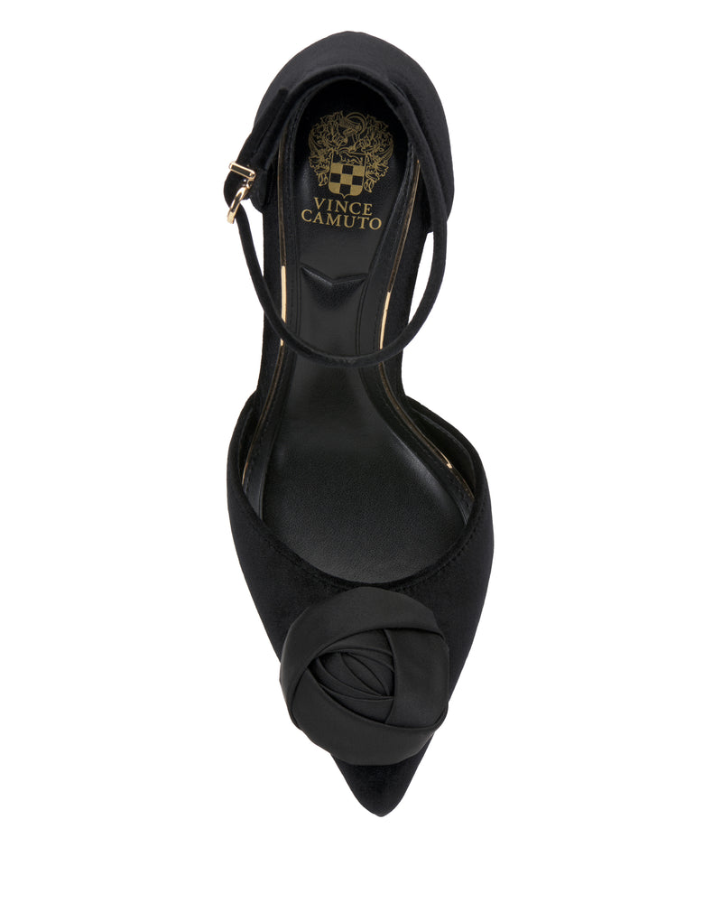 The Vince Camuto Mirezzo Pump is a black pointed-toe shoe with an ankle strap and a decorative flower detail on the toe, viewed from above.