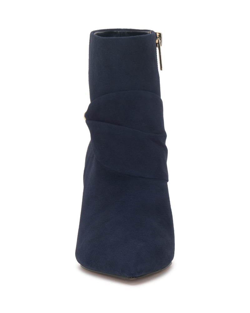 Front view of the Vince Camuto Murlea Bootie in navy blue suede, featuring a pointed toe, side zipper, and a folded, layered design across the front.
