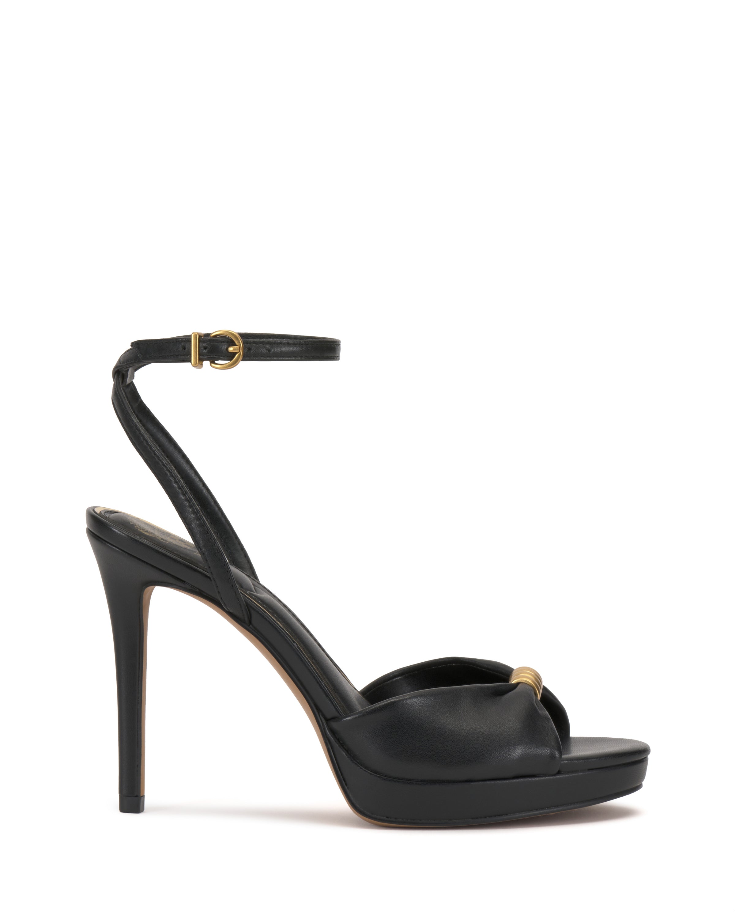 The Vince Camuto Neala Sandal is a black high-heeled sandal with an ankle strap, gold buckle, and small gold accent on the toe strap, shown on a white background.