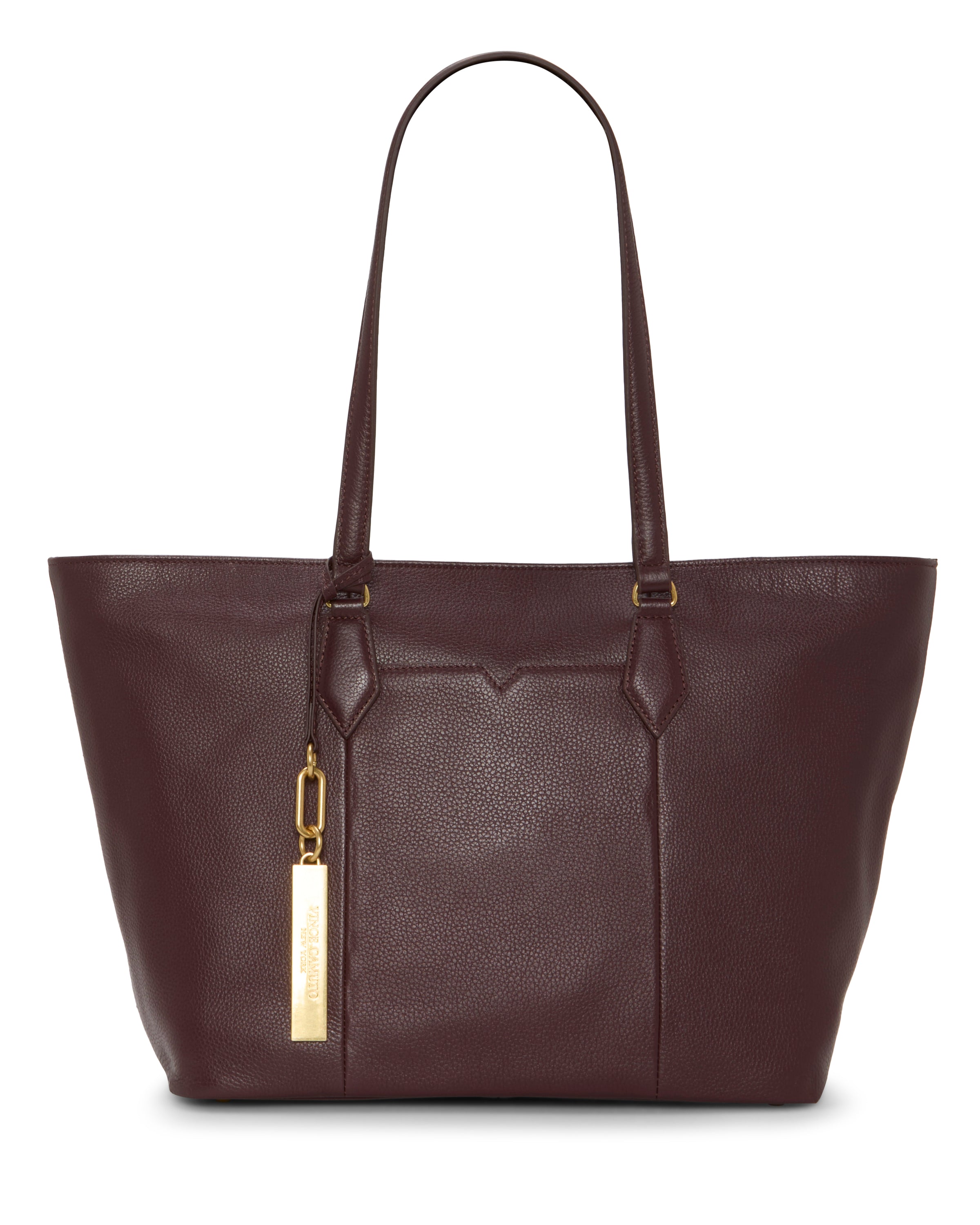 The Vince Camuto Noemi Tote Bag is a large, dark brown leather tote with two long shoulder straps and a gold rectangular tag. Its minimalist design features minimal stitching for a classic, elegant look.