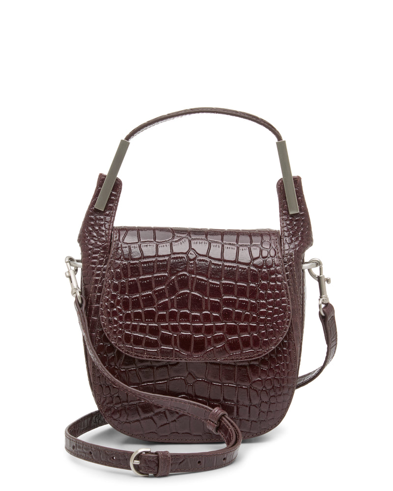 The Noli Crossbody Bag by Vince Camuto features dark brown faux-crocodile leather, a convenient top handle, flap closure, and an adjustable shoulder strap. Displayed against a white background, this stylish accessory is the perfect choice for any occasion.
