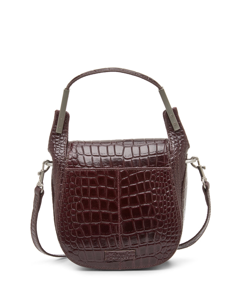 The Vince Camuto Noli Crossbody Bag is a stylish dark brown, crocodile-embossed leather handbag featuring a short top handle and a detachable shoulder strap, displayed against a white background.