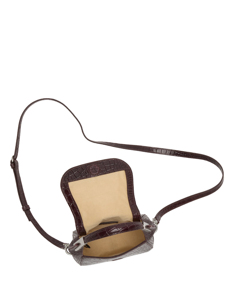 The Noli Crossbody Bag by Vince Camuto features a long strap and opens to reveal a beige interior lining, making this brown leather accessory a stylish choice for everyday use.