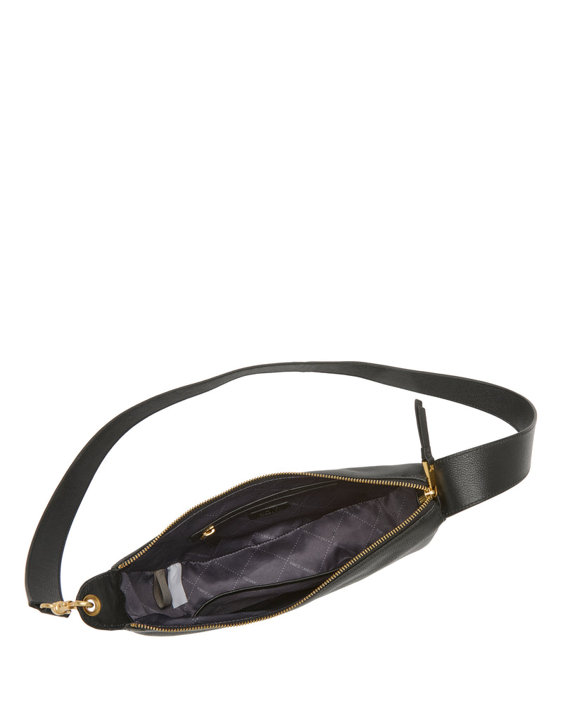 The Vince Camuto Orlie Crossbody Bag, crafted in black leather and featuring a gold zipper, is displayed from above with its interior exposed. The inside boasts a gray fabric lining and a convenient small pocket. Designed for durability and everyday elegance, this sophisticated accessory includes a strap extending to both sides, combining style with practicality.