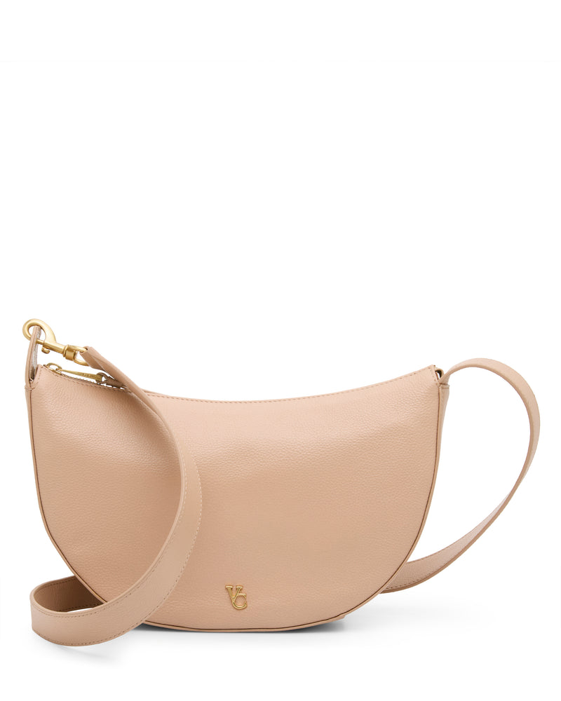 The Vince Camuto Orlie Crossbody Bag features a beige, crescent-shaped design with a gold-tone logo and a matching adjustable strap, displayed on a white background—an effortlessly stylish accessory for any ensemble.