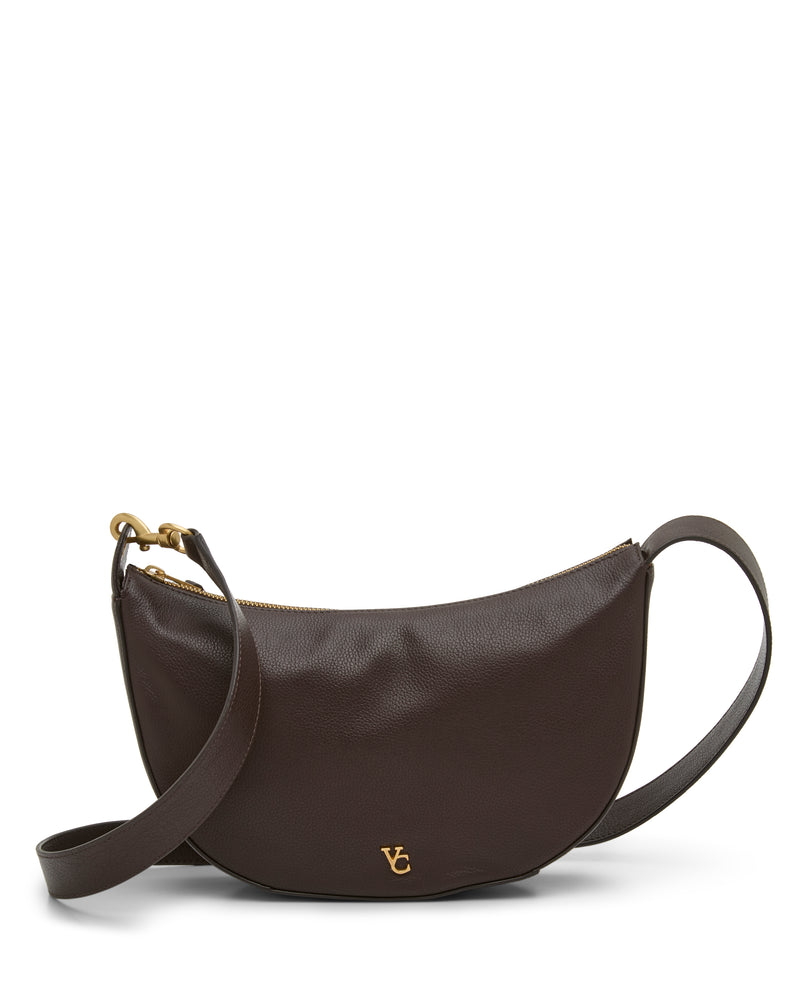 The Vince Camuto Orlie Crossbody Bag is crafted from dark brown leather in a curved silhouette, featuring a gold zipper, matching adjustable strap, and a small gold VC logo on the front. Showcasing high-quality craftsmanship, this modern accessory is photographed on a white background.