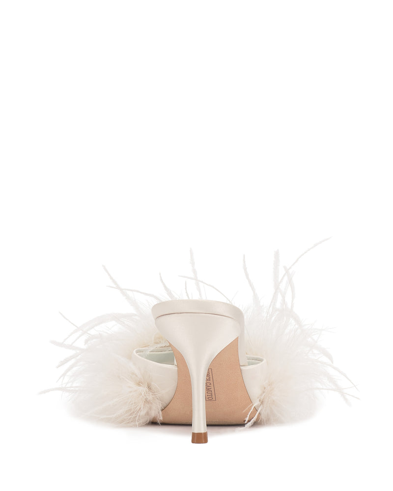 The Paelly Feather Mule by Vince Camuto is a white satin high-heeled shoe, seen from the back, with white feathers decorating the sides and heel, set against a plain white background.