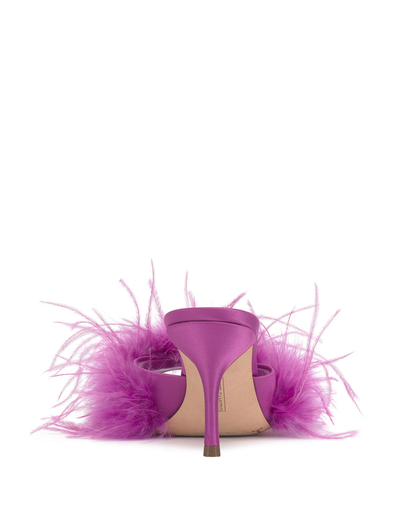 The Vince Camuto Paelly Feather Mule is a magenta high-heeled shoe featuring pink feather details around the sides and back, shown from behind on a white background.