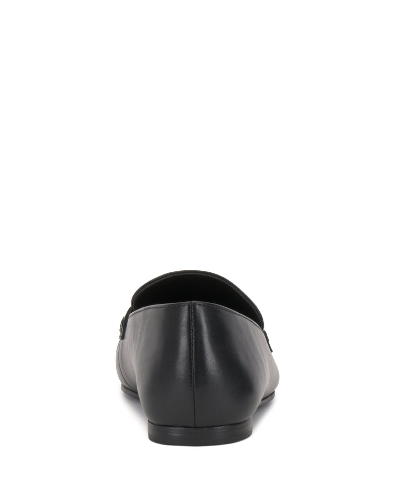 The Vince Camuto Paelyn Penny Loafer, a black leather moccasin-inspired shoe, is shown from the back on a white background.