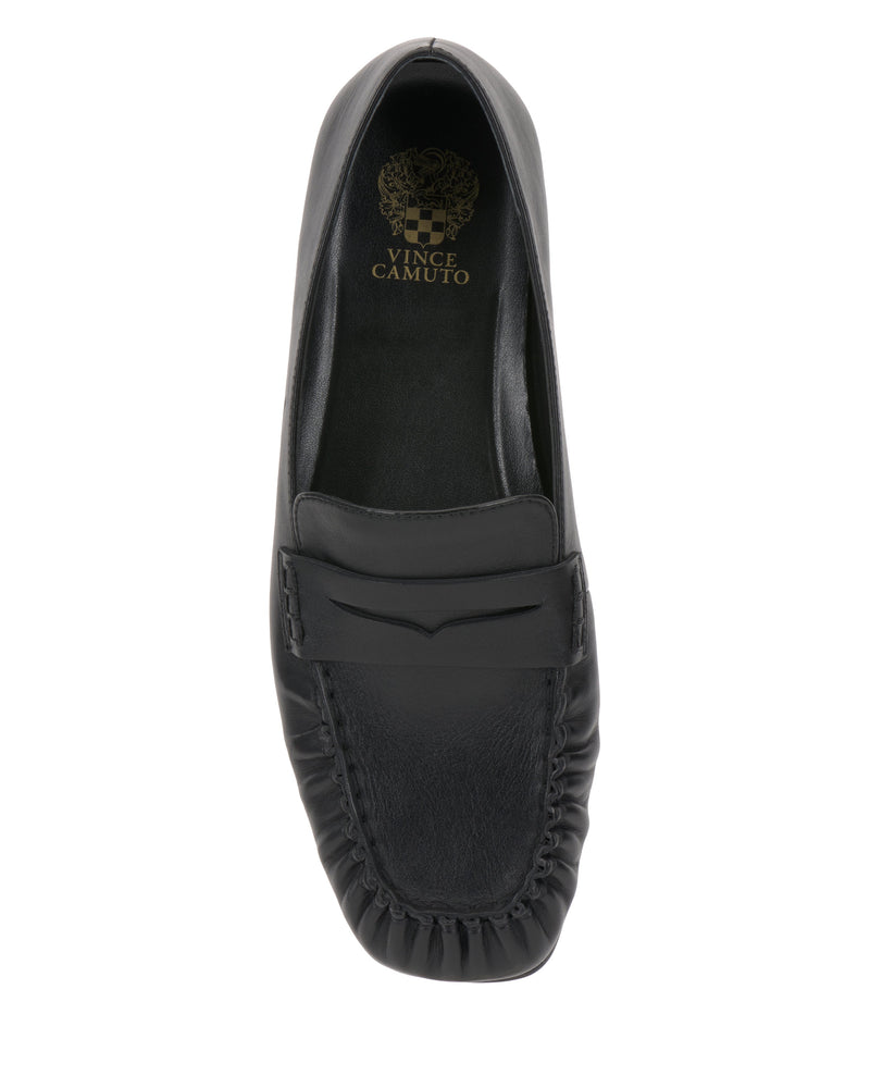 Top view of the Vince Camuto Paelyn Penny Loafer, showcasing black leather, a stitched rounded toe, moccasin-inspired details, a penny slot on the upper, and Vince Camuto branding on the insole.