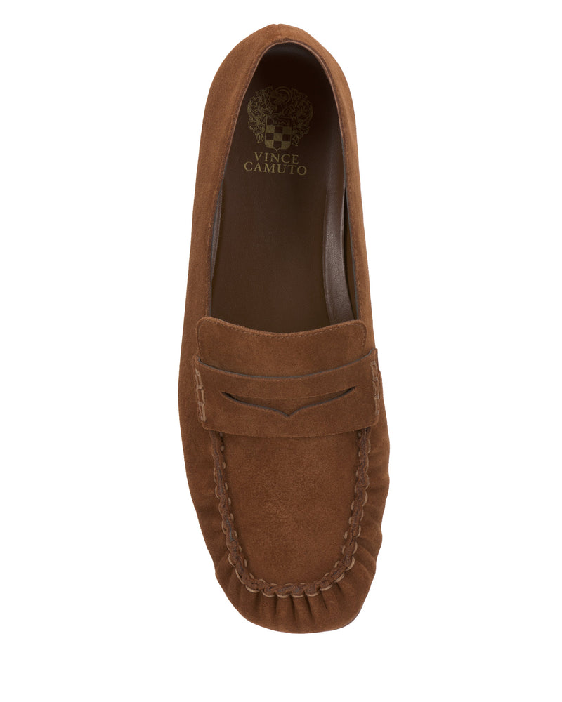 The Vince Camuto Paelyn Penny Loafer is a brown suede slip-on with moccasin stitching, a classic penny slot, and a branded gold insole for effortless style.
