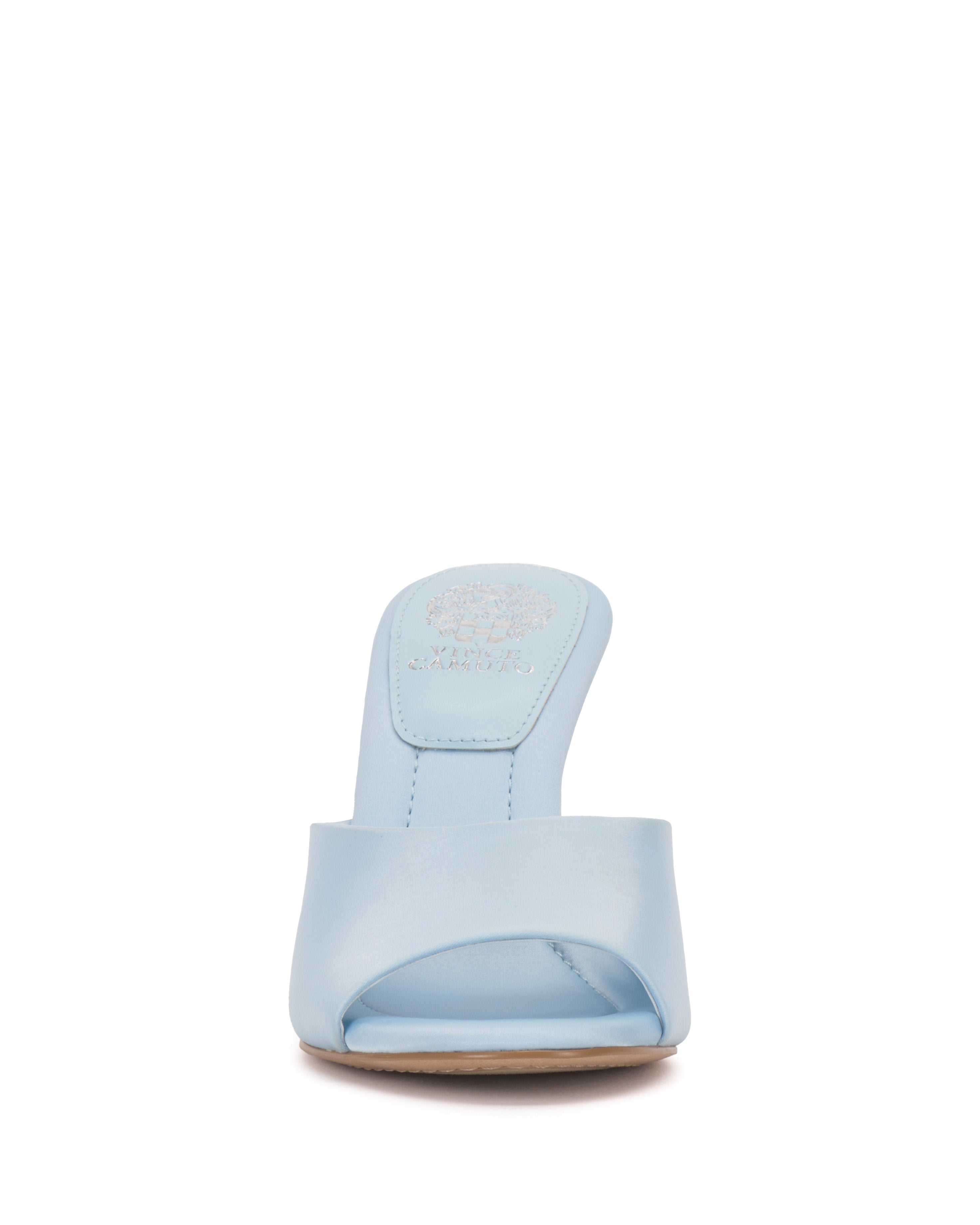 Front view of the Paigely Mule by Vince Camuto in light blue. This open-toe sandal has a wide front strap, flared heel, and brand logo on the insole, shown against a white background.