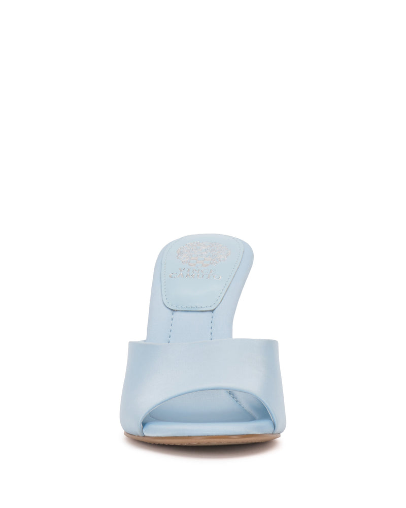 Front view of the Paigely Mule by Vince Camuto in light blue. This open-toe sandal has a wide front strap, flared heel, and brand logo on the insole, shown against a white background.