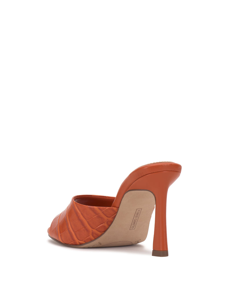 The Vince Camuto Paigely Mule is shown from the back on a white background, featuring an orange minimalist design with quilted texture, open toe, and thin flared heel.