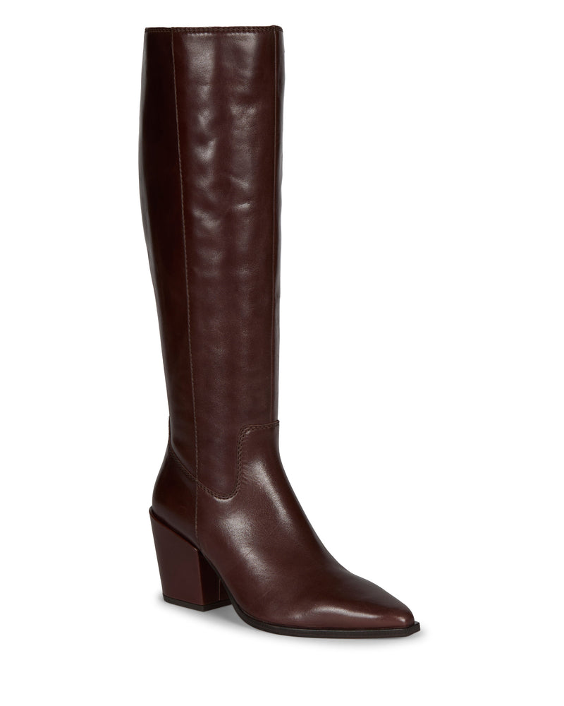 The Pamlia Knee High Boot by Vince Camuto is a tall, dark brown leather boot with a pointed toe, mid-height block heel, and subtle western styling, shown against a white background.