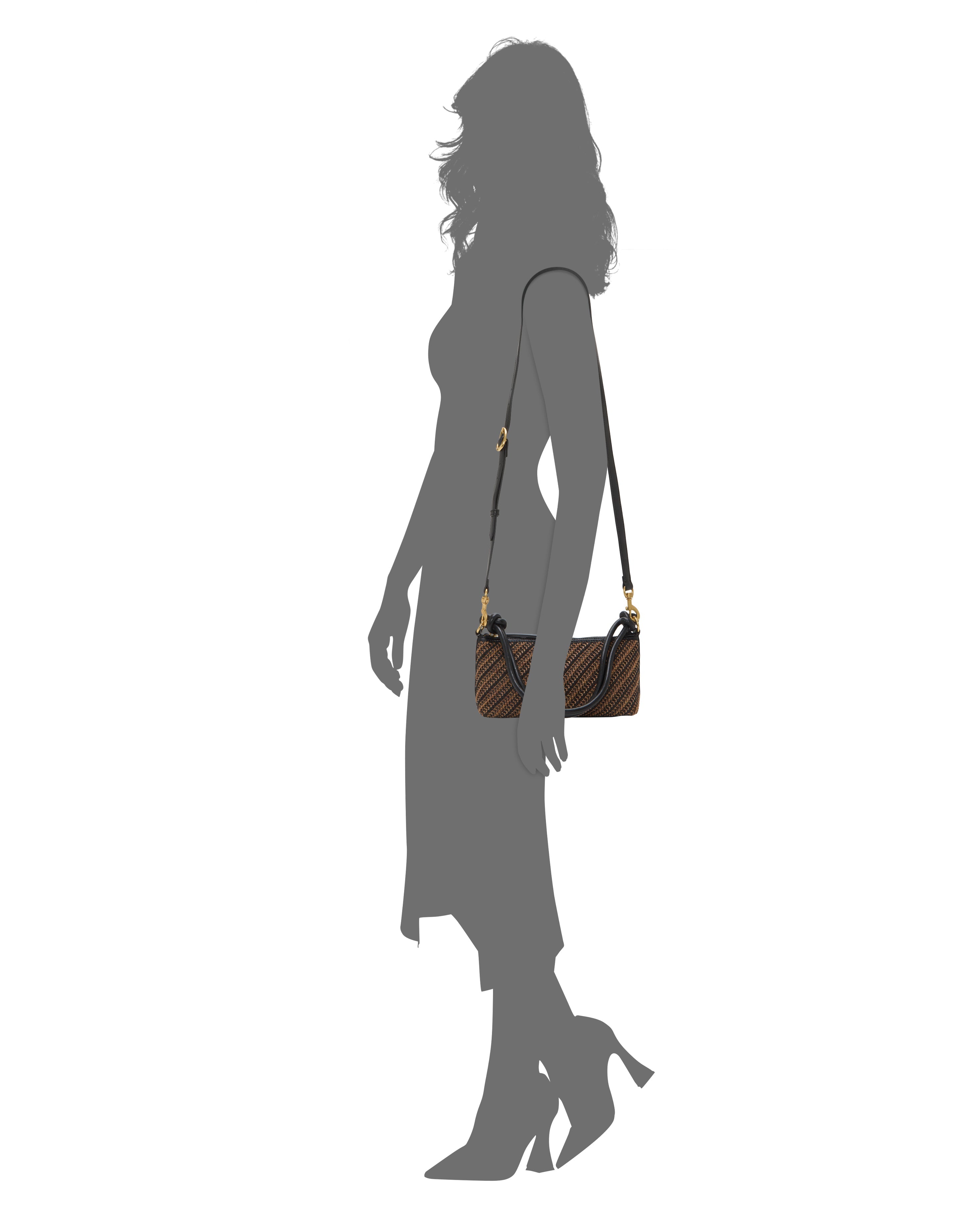 A woman in a mid-length dress and heels carries the Vince Camuto Paula Crossbody Bag—small, brown with a black strap and gold hardware—against a plain white background.