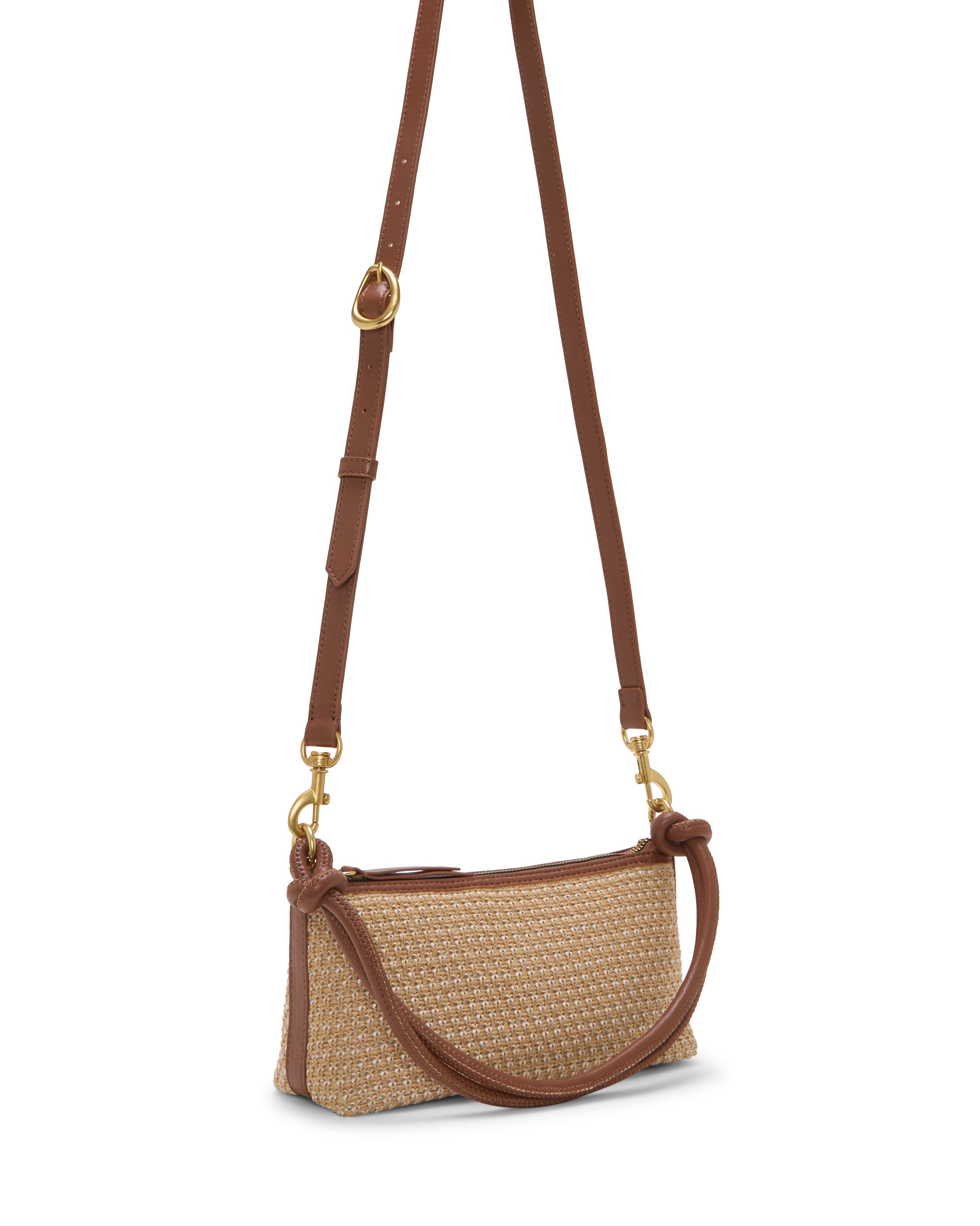 The Paula Crossbody Bag by Vince Camuto is a small, rectangular woven straw handbag featuring brown leather trim, an adjustable shoulder strap, and gold hardware, shown against a white background.