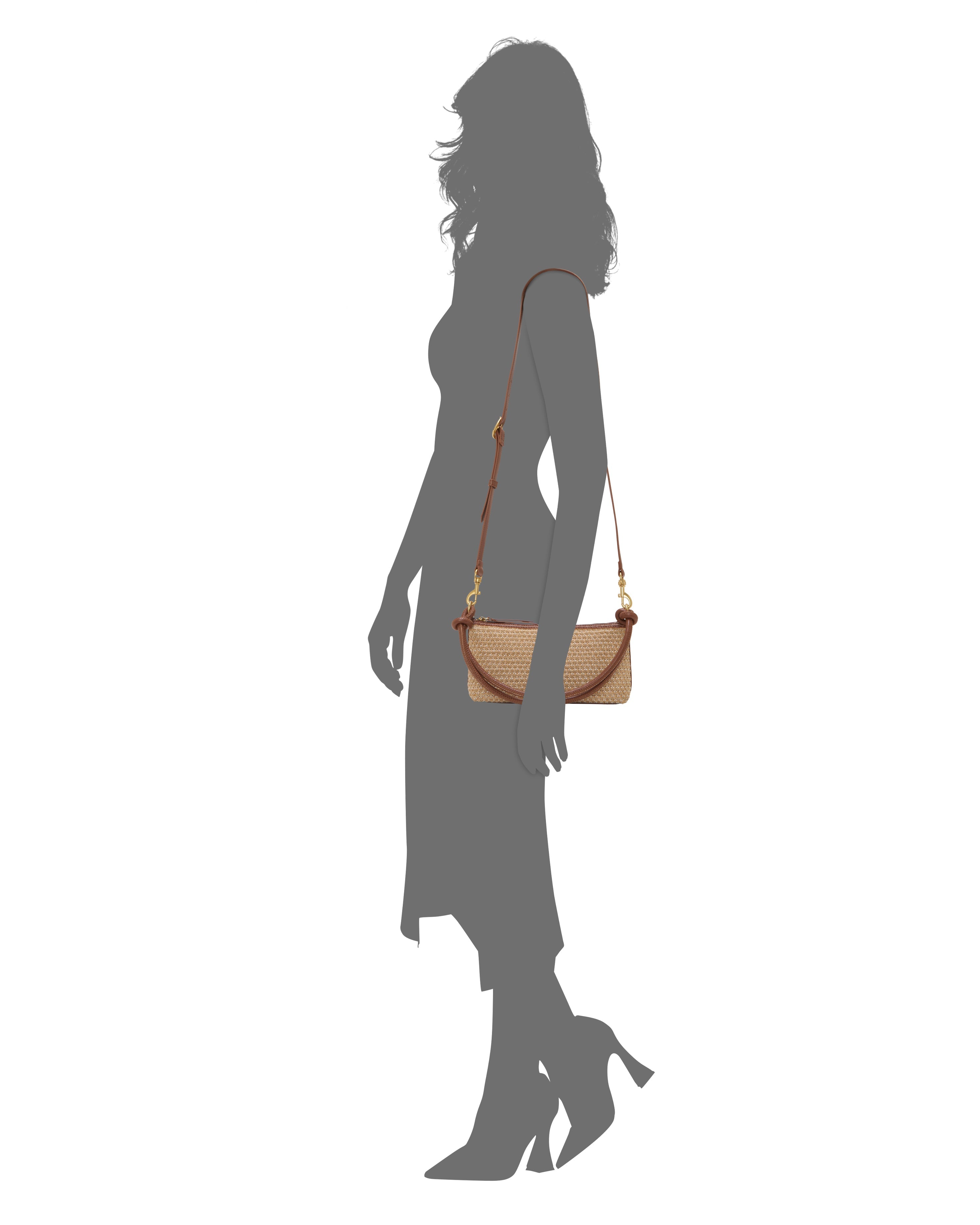 Silhouette of a woman in a dress and heels, shown in profile, with a beige and brown Vince Camuto Paula Crossbody Bag featuring a long strap on her shoulder.
