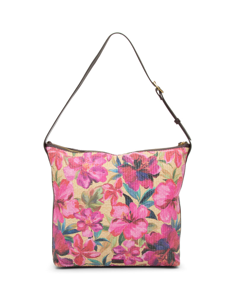 The Paula Shoulder Bag by Vince Camuto features a vibrant pink floral print on beige canvas with a single dark brown strap—an ideal accessory for carrying your summer essentials.