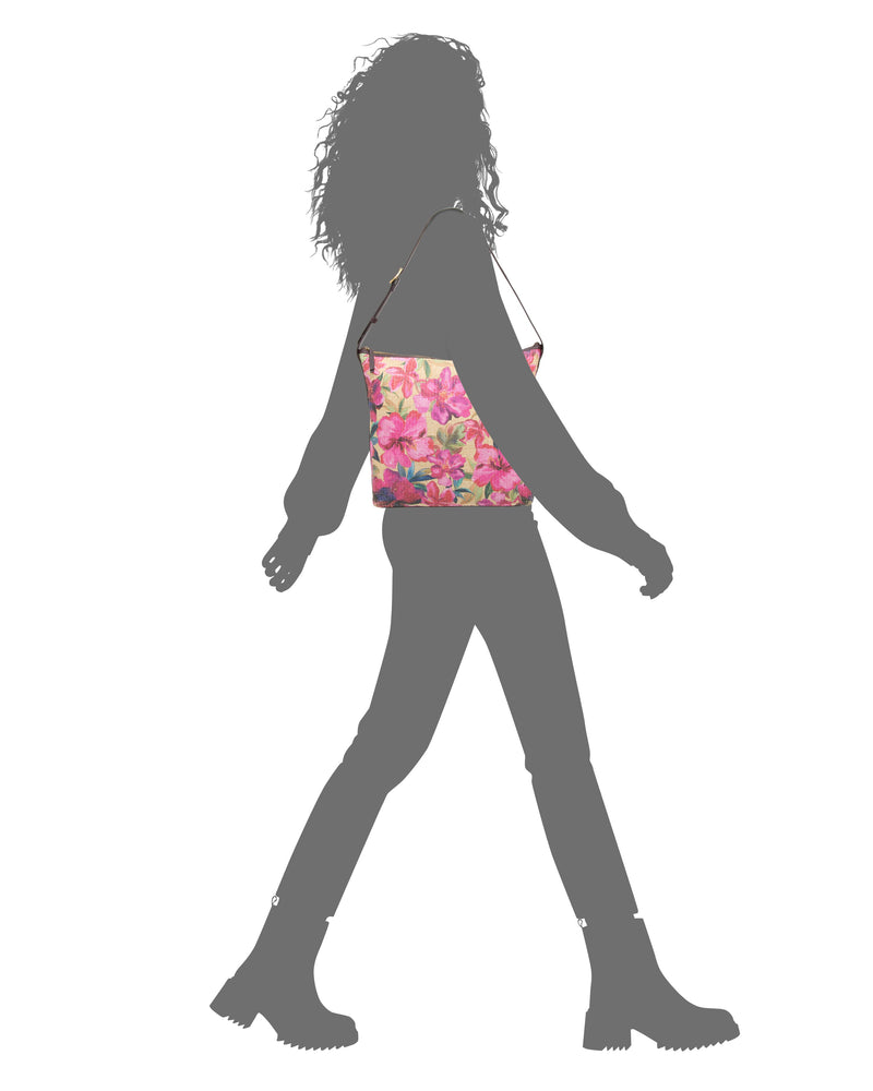 Silhouette of a person walking in boots, carrying the Vince Camuto Paula Shoulder Bag with a bright pink floral pattern—ideal for summer essentials—set against a white background.
