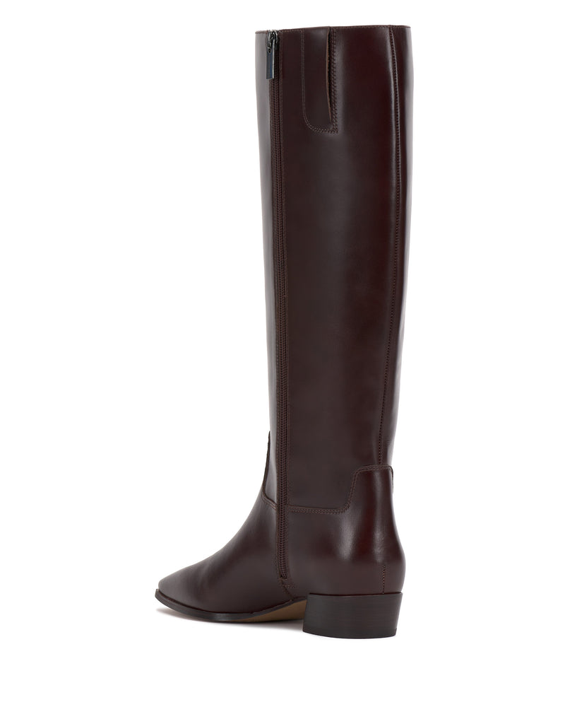 The Vince Camuto Pavla Narrow Calf Knee High Boot, in dark brown with western styling, a low block heel, and a side zipper, is shown from a rear-side angle on a white background.