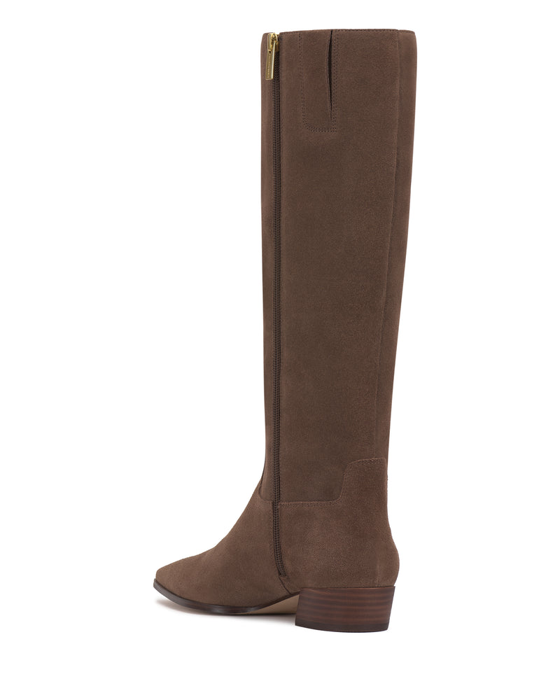 The Vince Camuto Pavla Knee High Boot in brown suede features a low block heel, side zipper, and almond-shaped toe, displayed in profile against a white background.