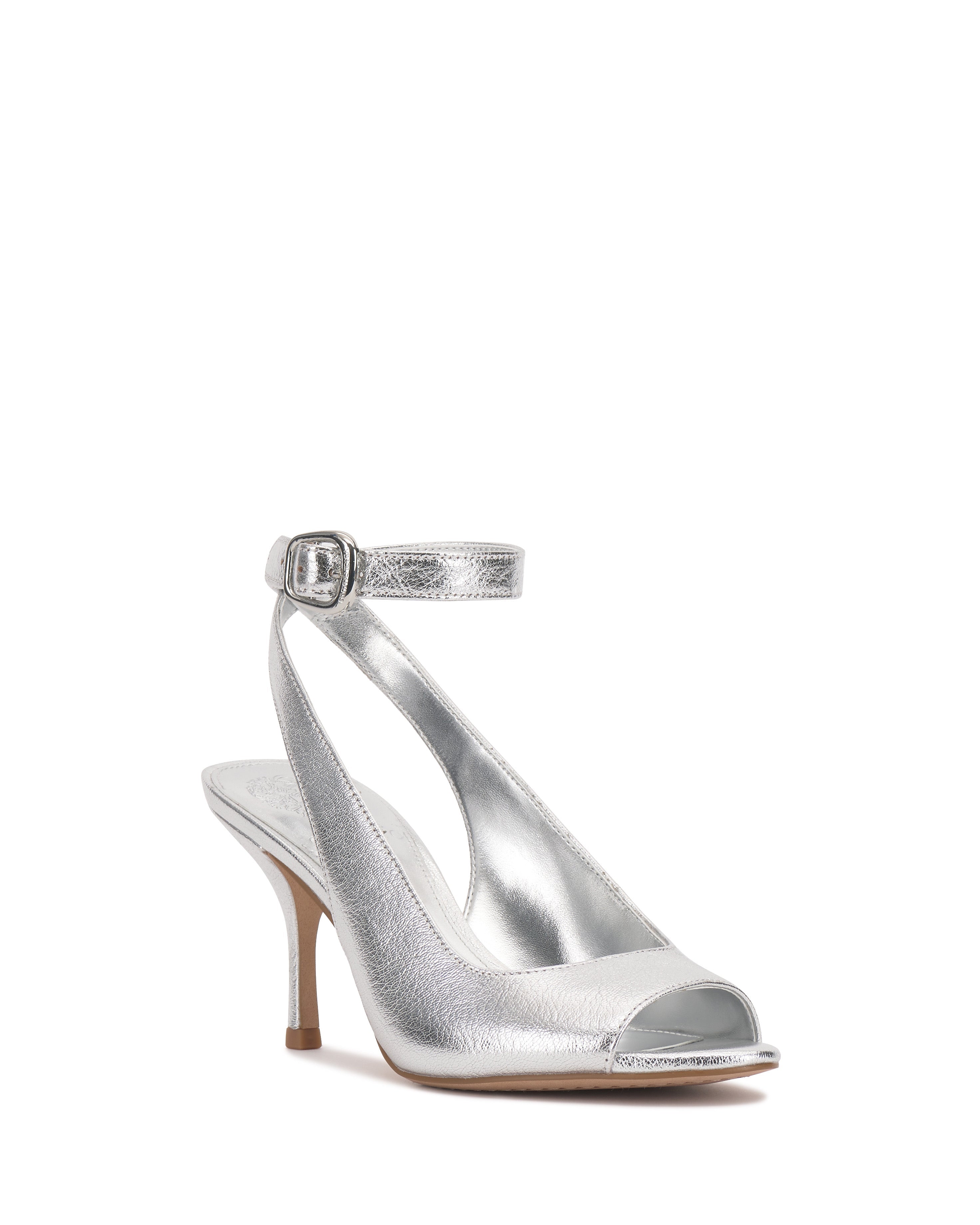 The Vince Camuto Pavles Sandal is a silver metallic peep toe with an ankle strap and buckle, featuring a mid-height heel for timeless elegance.