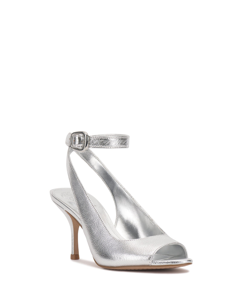 The Vince Camuto Pavles Sandal is a silver metallic peep toe with an ankle strap and buckle, featuring a mid-height heel for timeless elegance.