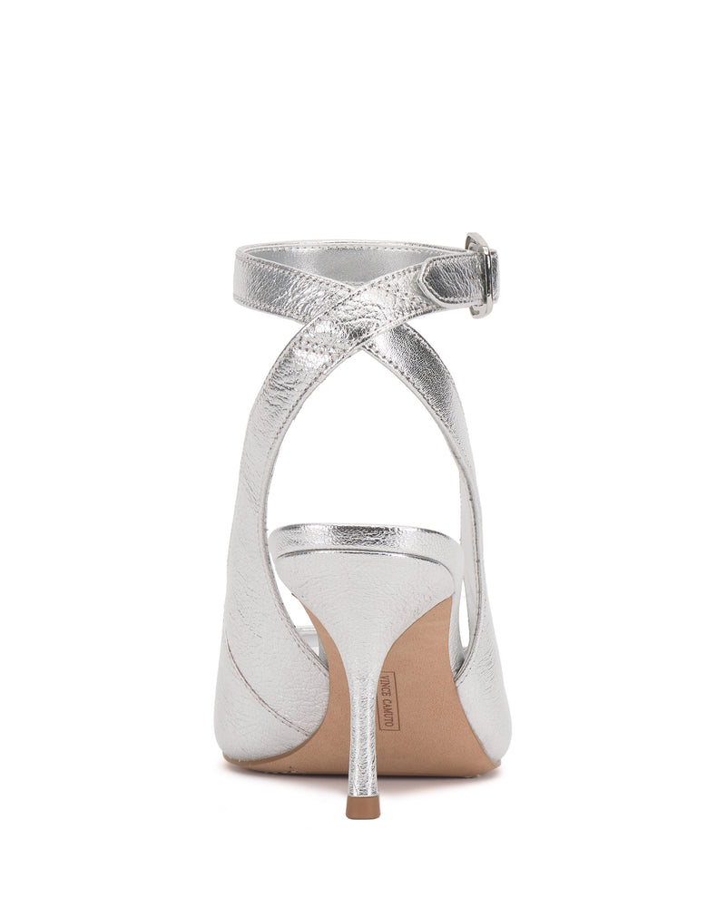 The Vince Camuto Pavles Sandal, a silver high-heeled shoe with a pointed toe and crisscross ankle strap with buckle, exudes classic elegance in this back view against a white background.