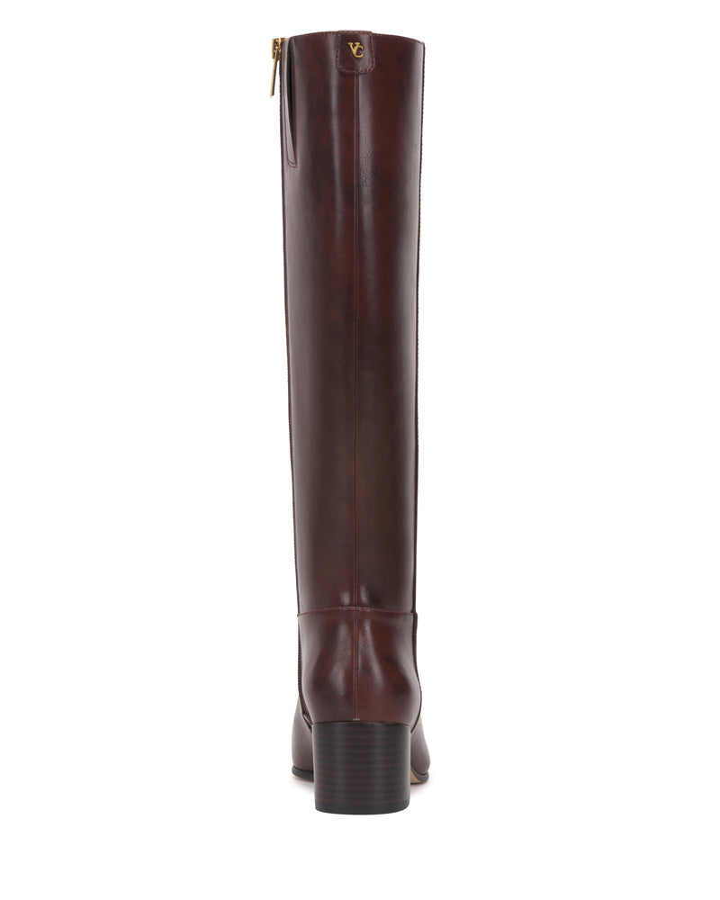 A rear view of the Vince Camuto Pazzla Narrow Calf Knee High Boot highlights its tall, dark brown leather design with a block heel, back zipper, and a small gold logo at the top of the shaft.