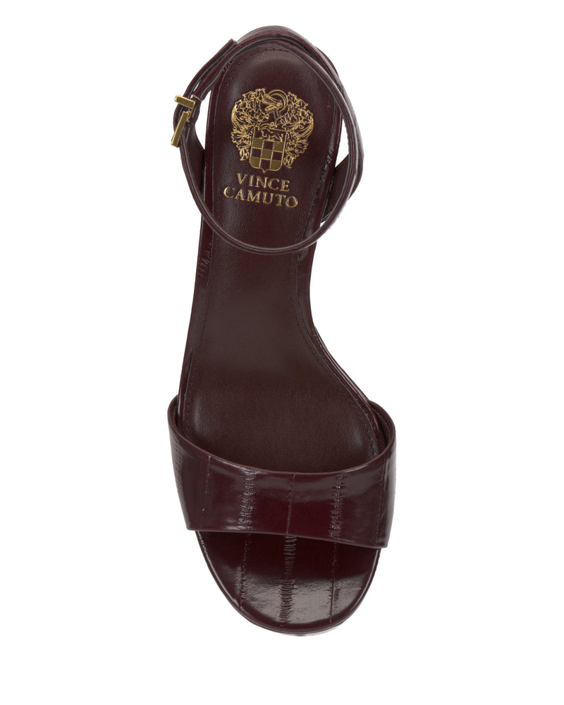 A top view of the Vince Camuto Pendreya Platform Sandal in dark burgundy shows its block heel, ankle strap with gold buckle, and the brand's gold logo printed on the insole, highlighting its retro style elegance.