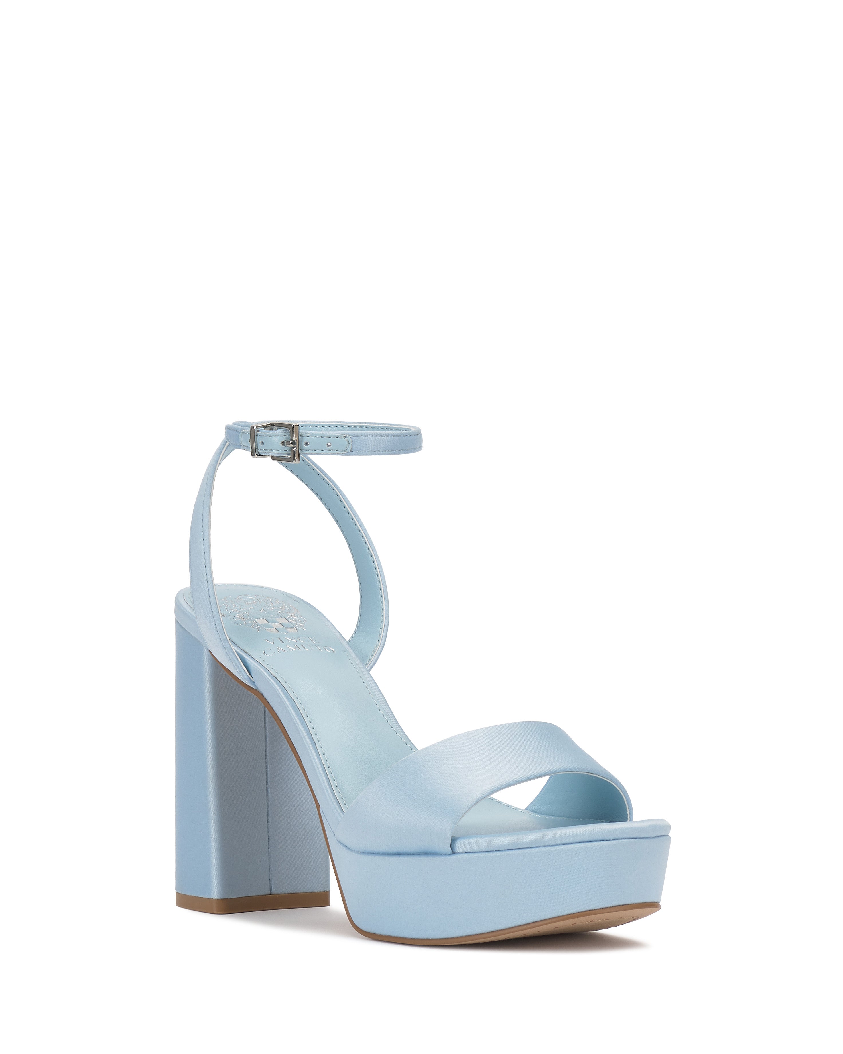 The Pendry Platform Sandal by Vince Camuto features a light blue hue, retro-inspired thick block heel, wide toe strap, and adjustable buckled ankle strap, all showcased against a white background.