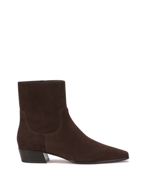 The Pertula Bootie by Vince Camuto features dark brown suede, a low stacked heel, and a slightly pointed toe, shown in side profile against a plain white background.