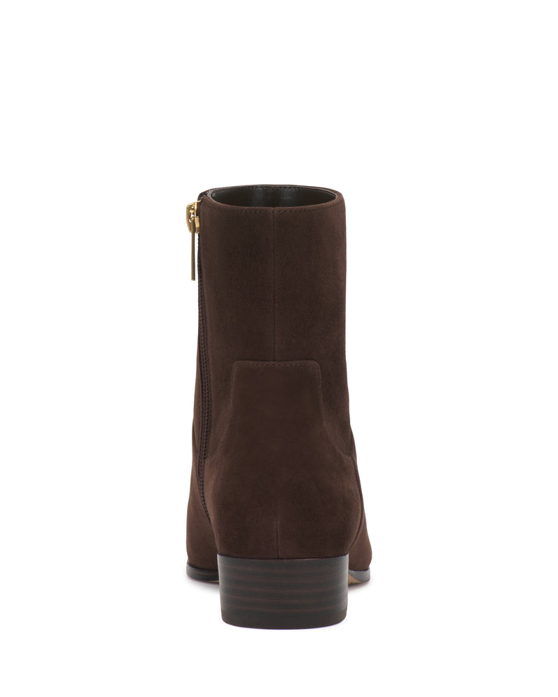 The Pertula Bootie by Vince Camuto is shown from the back, featuring brown suede, a short stacked heel, and a side zipper with a gold pull.