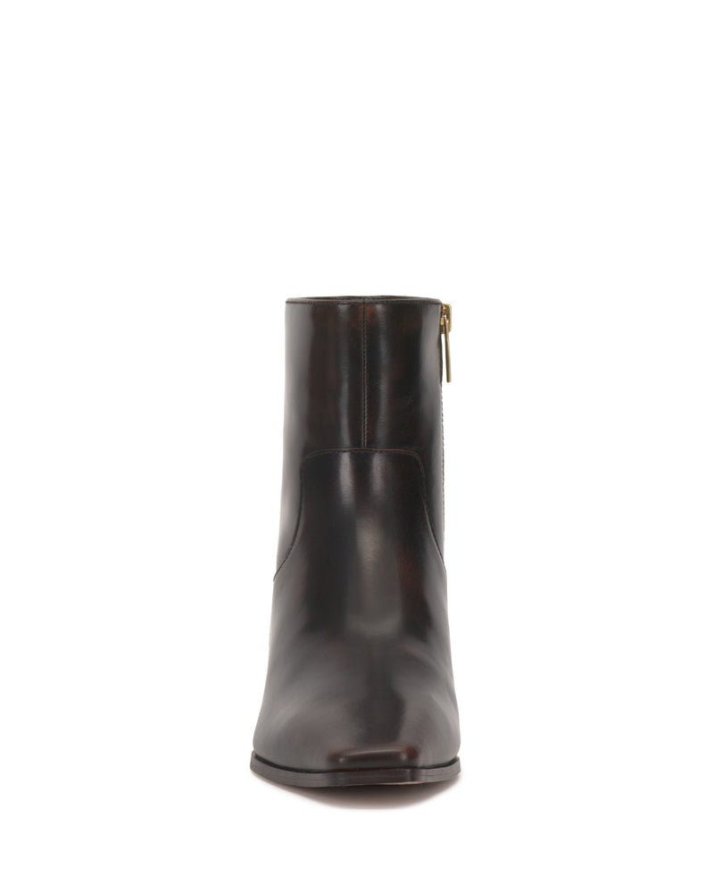 Front view of the Vince Camuto Pertula Bootie in dark brown leather, showcasing a simple design with a pointed toe ankle bootie silhouette and a side zipper.