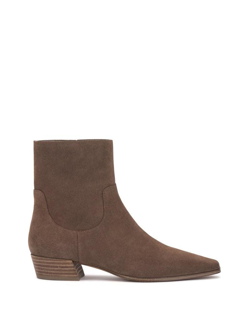 The Pertula Bootie by Vince Camuto features rich brown suede in a pointed-toe ankle silhouette with a low block heel and subtle stitching details. Styled in side profile against a white background, this design exemplifies refined style with modern simplicity.