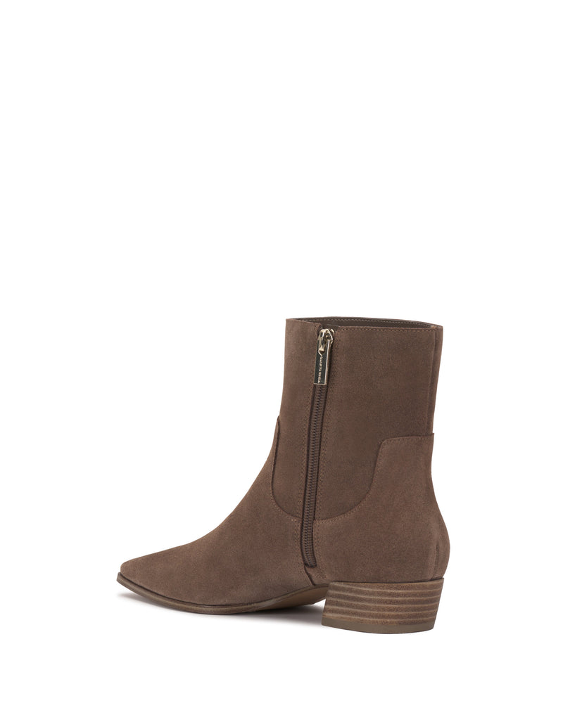 Side view of the Pertula Bootie by Vince Camuto, featuring brown suede, a pointed toe, a low stacked block heel, and a visible side zipper, isolated on a white background.